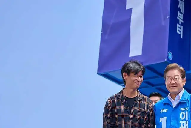 제21대 1번 이재명 대선 후보가 유세 현장에서 박혁권 배우와 함께 기념 촬영을 하고 있습니다.