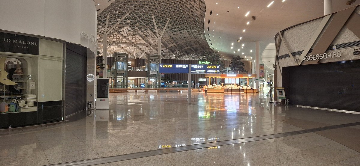 Transfer hall inside Incheon Airport Terminal 2 with a high lattice ceiling and a Transfer sign