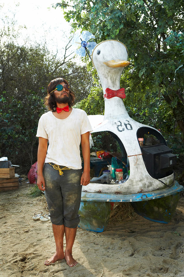 오리배로 만든 집 앞에 요상한 모습을 한 남자 김씨가 서 있는 모습