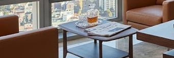금리 인하 투자 성공을 상징하는 고급스럽고 미니멀한 개인 사무실 전경. 탁 트인 도시 전망과 정돈된 데스크가 어우러진 전문적인 분위기의 이미지