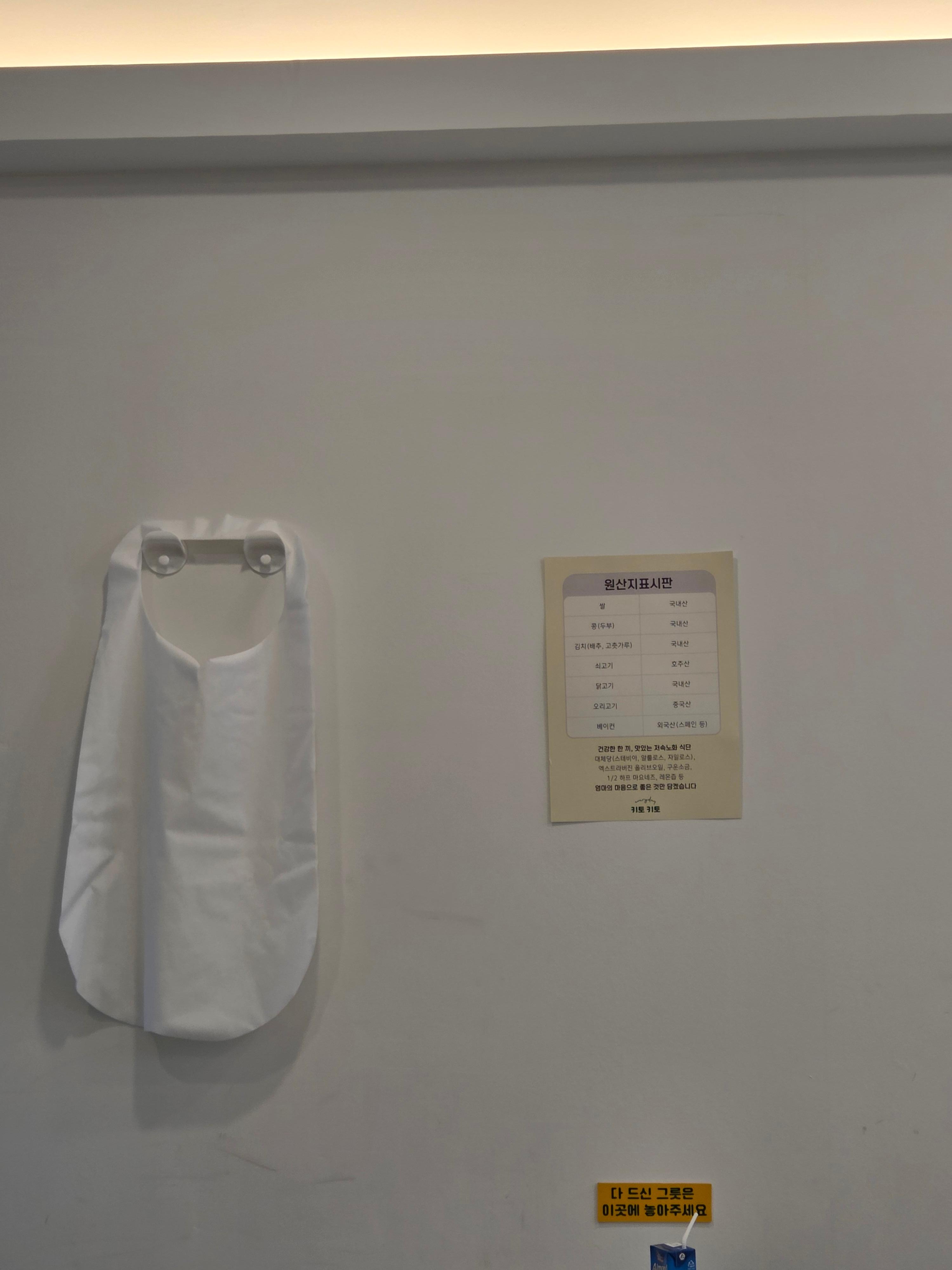 키토키토 매장 벽면에 부착된 원산지 표시판과 앞지마가 걸려있는 모습