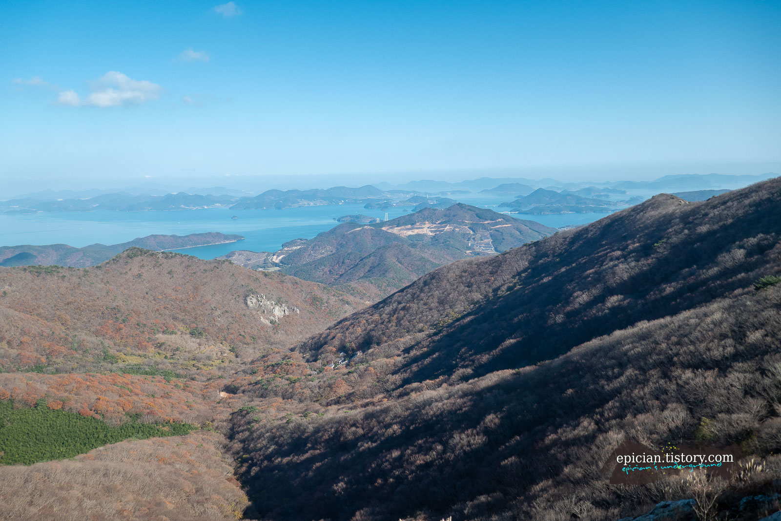 파란 하늘을 배경으로 산골짜기 너머로 보이는 여수의 풍경