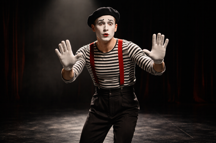 스포트라이트 아래 보이지 않는 벽을 표현하는 전통 마임 배우