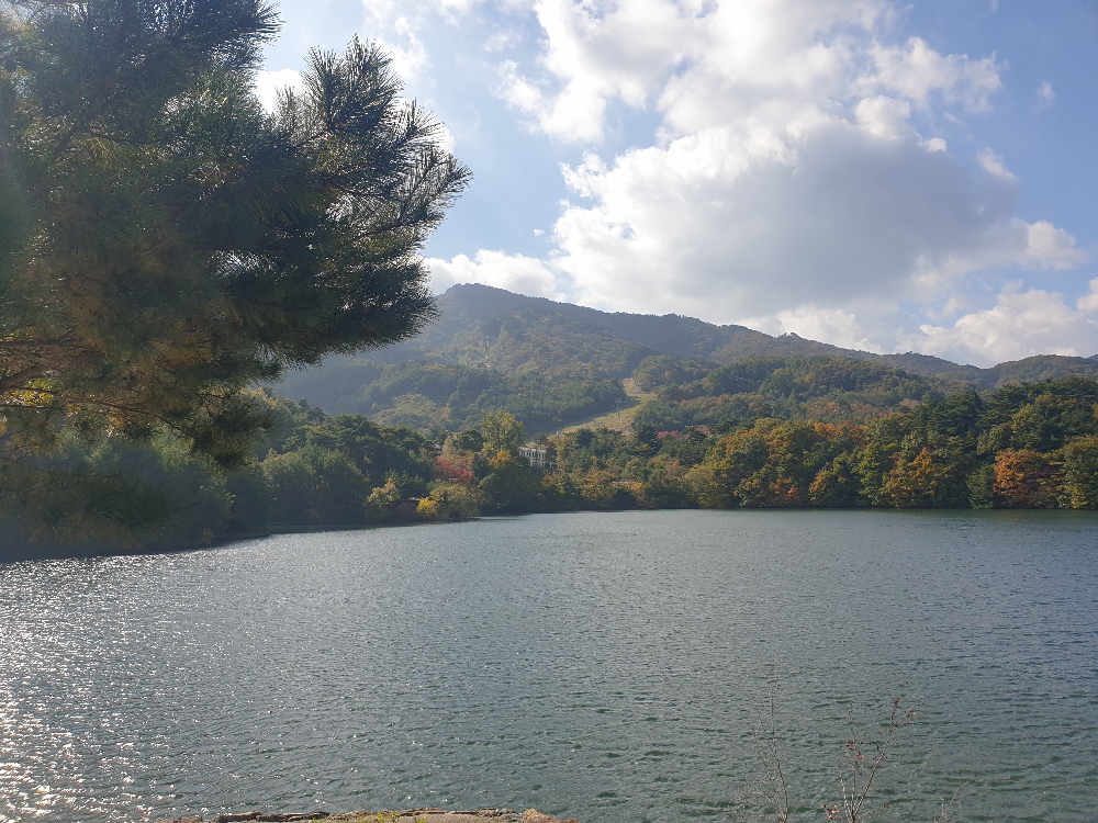 큰 호수 저편 건물들이 보인다. 건물은 마치 산장처럼 보인다.