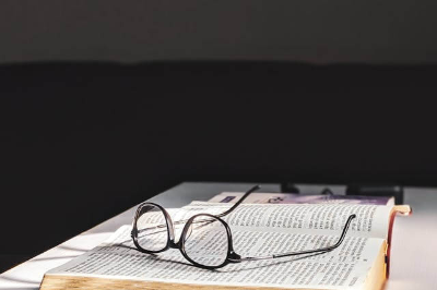 작은 글씨의 책과 위에 놓인 안경