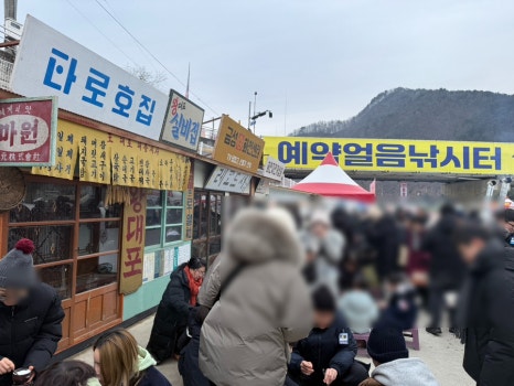 화천 산천어축제에서 방문객들이 추억의 뽑기와 다양한 민속놀이를 체험하며 즐기는 모습