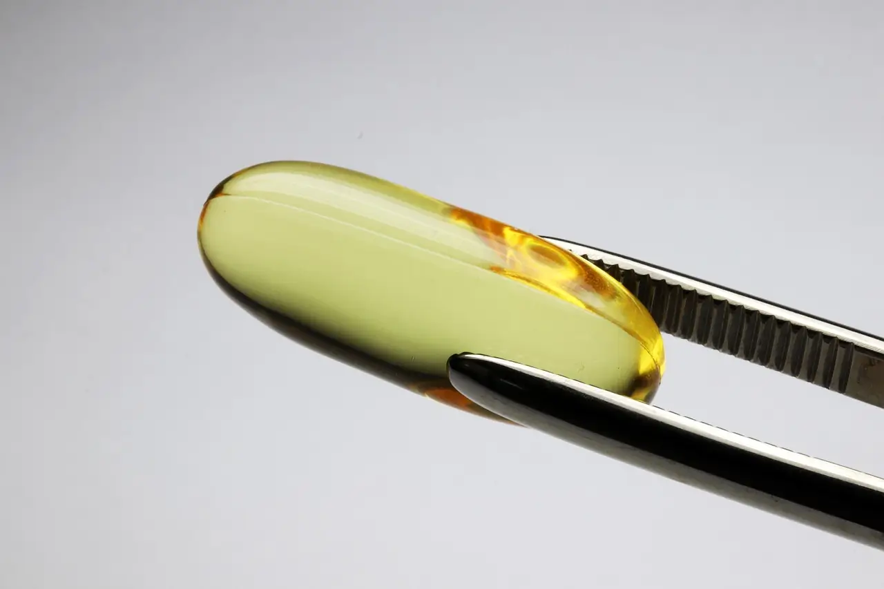 핀셋으로 알 약 한 개를 잡고 있는 모습의 이미지