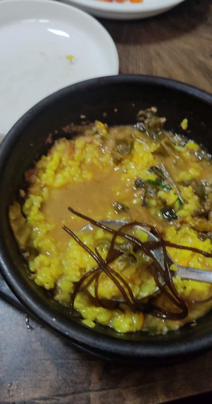 추어탕에 밥을 말고 비빔고추와 톳나물을 얹어 먹는 모습