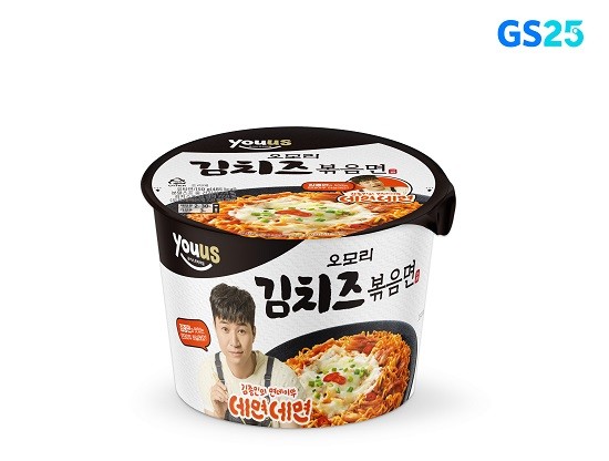 흰색과-검은색이-조화된-용기형-오모리-김치즈볶음면-제품이-중앙에-배치되어-있고-뚜껑과-측면에는-치즈가-올라간-김치볶음면-사진과-홍보모델-김종민의-이미지가-함께-디자인되어-있는-구성