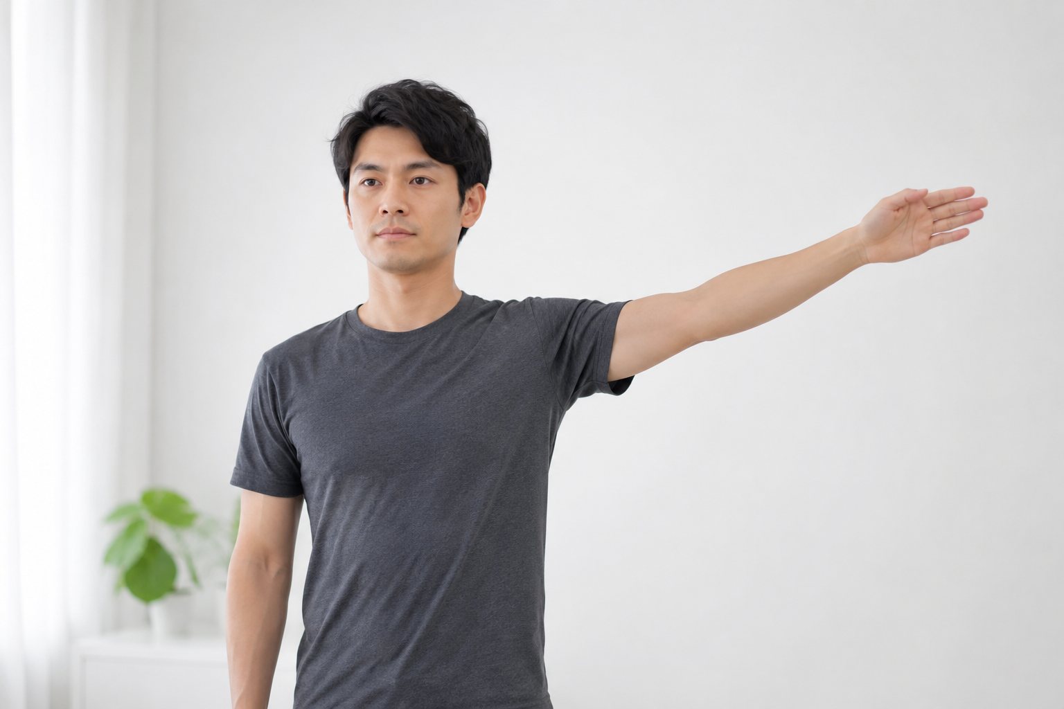 한쪽 팔을 옆으로 어깨 높이까지 들어 올려 어깨 움직임을 확인하는 남성