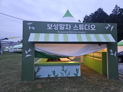 몽골텐트 전면에 커스텀 아치와 실사출력물을 적용한 행사부스 제작 모습