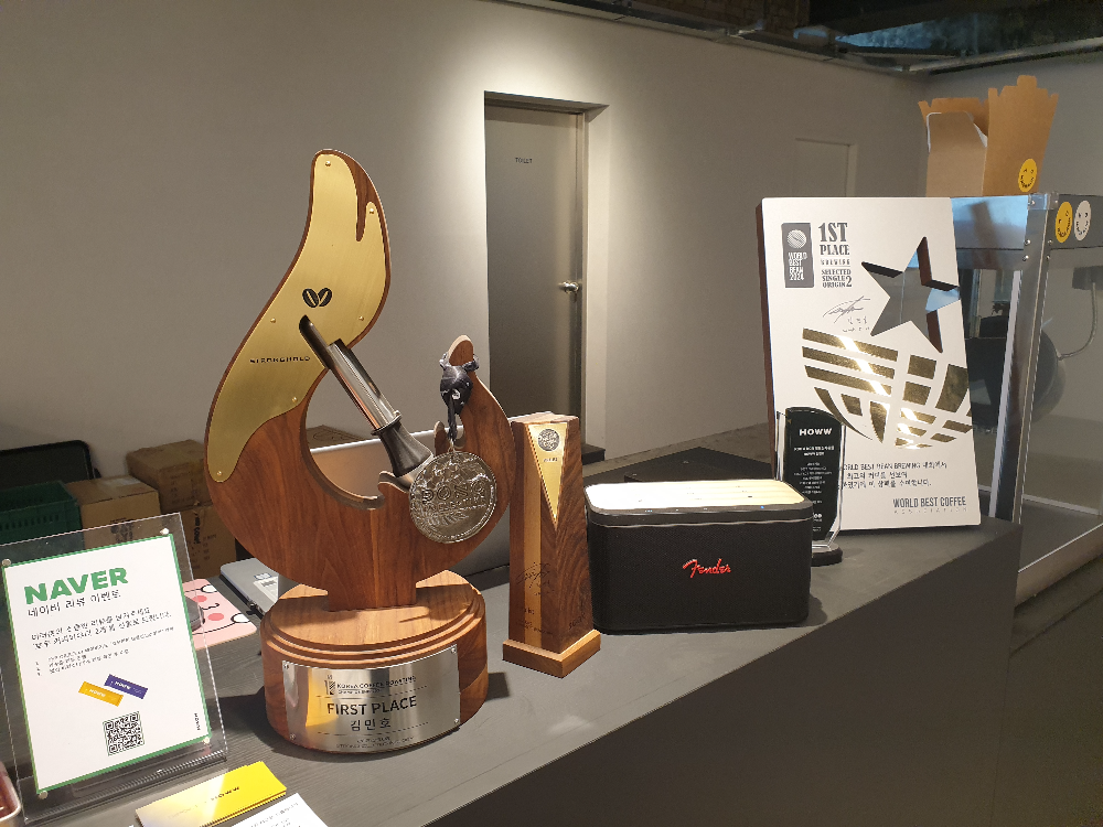 로스팅 대회우승 상패들이 테이블 위에 전시되어 있다.