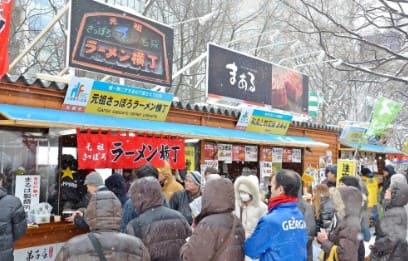 사람들이 노점상 앞에 서있다.