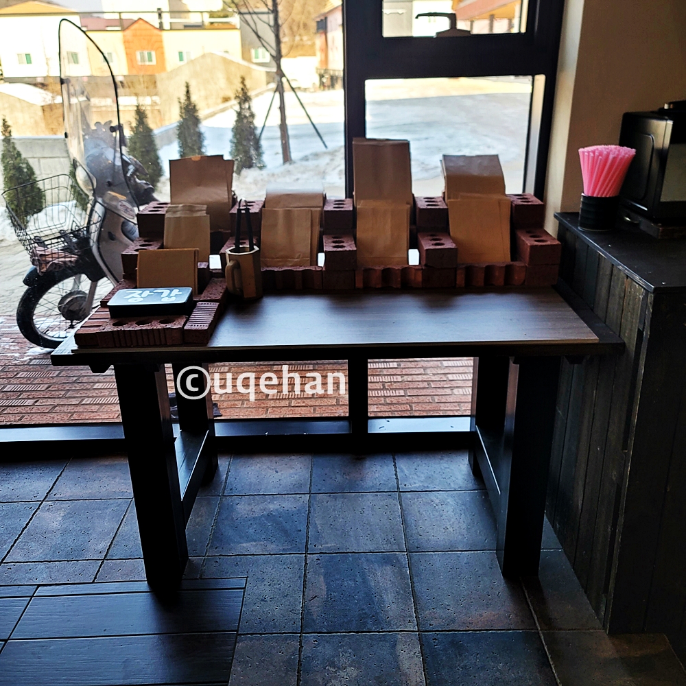 카페 럿지 셀프바에 휴지, 빨대등이 올려져 있다.