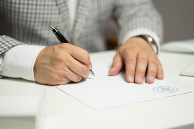 책상 위에서 문서에 서명하거나 작성하는 모습
