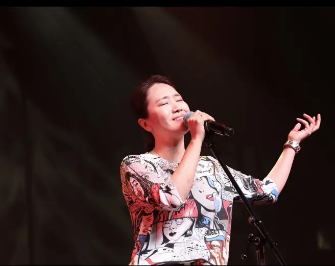 싱어게인3- 검은배경 꽃무늬 반팔 블라우스를 입고 마이크를 들고 노래하는 강성희