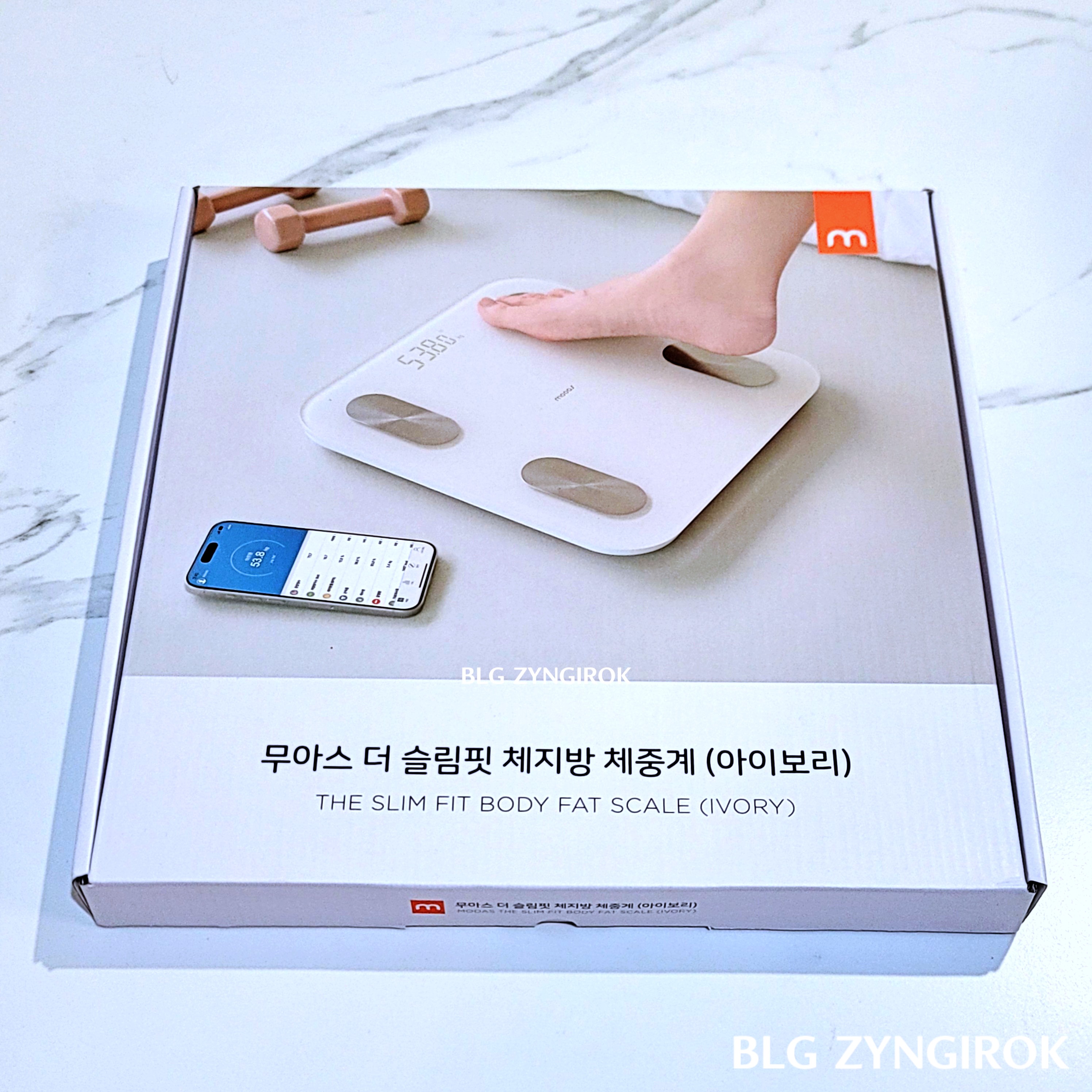 무아스 더 슬림핏 체지방 체중계 상자가 테이블 위에 놓여있다.