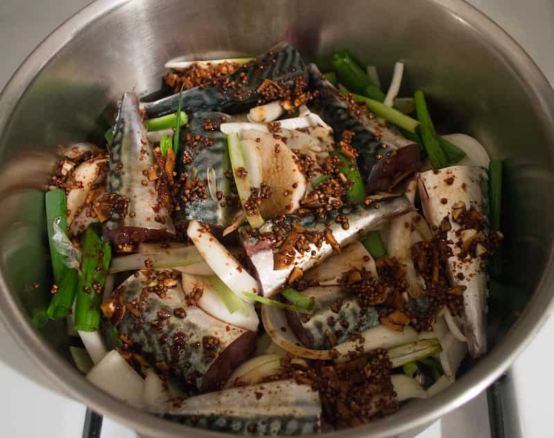 손질된 고등어와 무를 냄비에 층층이 올리고 양파, 고추, 마늘을 곁들인 고등어조림 조리 직전 모습