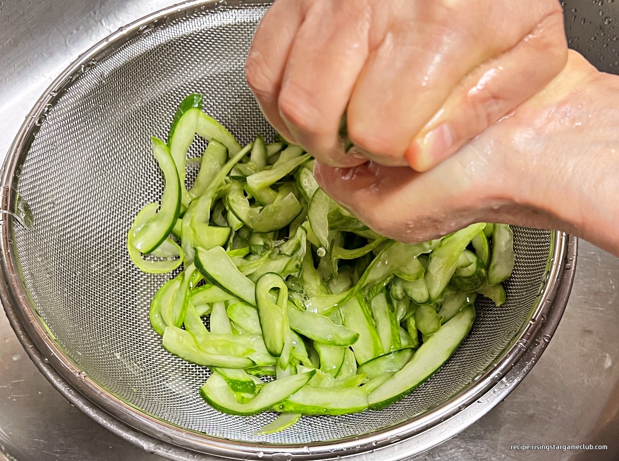 냉면 고명용 절인 오이의 물기를 제거하기 위해서 두손으로 꼭 짜고 있는 사진