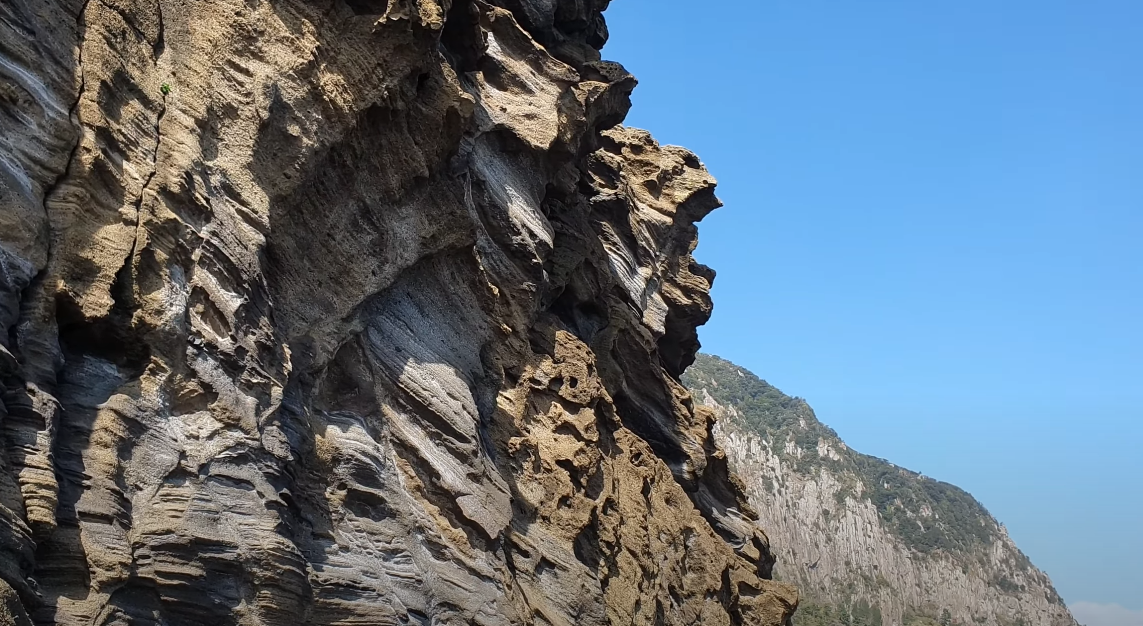 특이한 지질석을 암벽으로 볼 수 있는 용머리 해안에서 슬며시 머리를 들어 내는 산방산의 모습