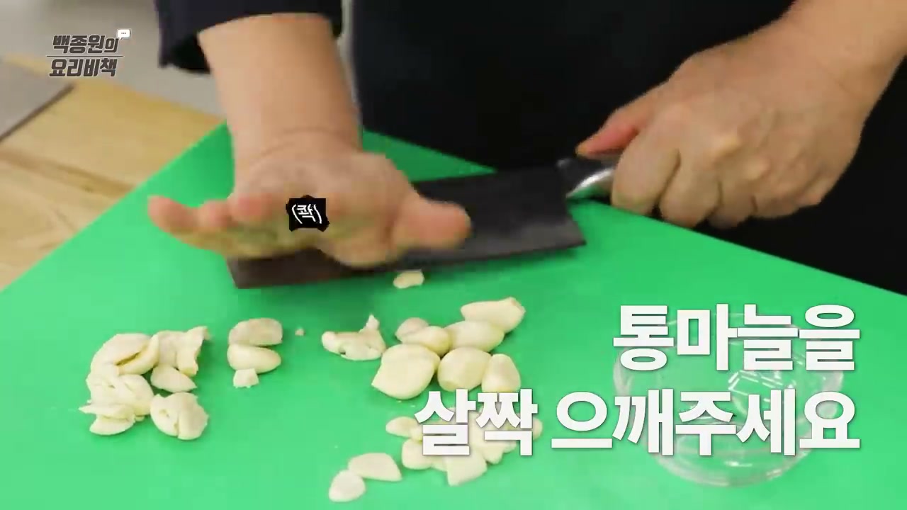 통마늘을 칼로 살짝 으깨는 장면