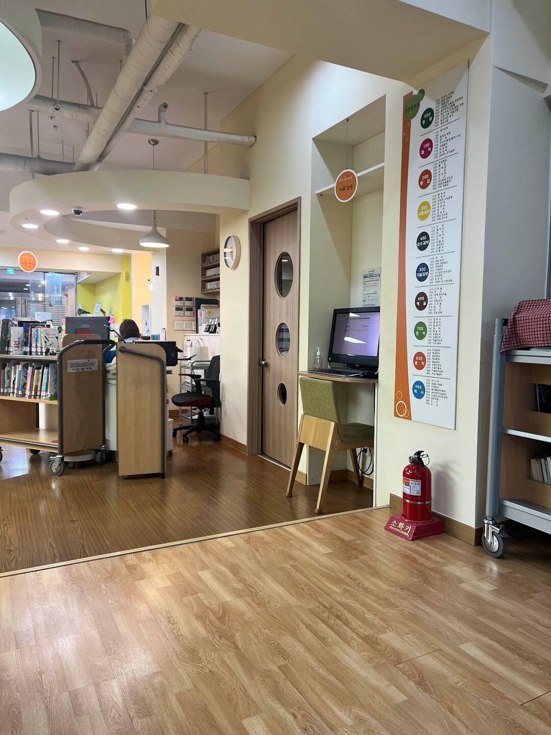 꿈마루 어린이도서관 좌식 독서 공간 회원가입 및 카드 발급을 진행하는 도서관 안내데스크 모습