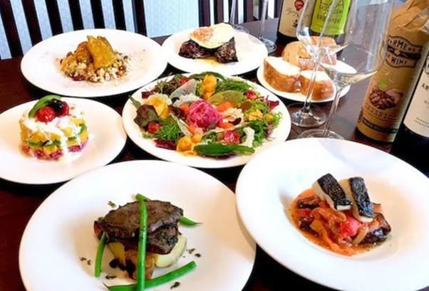 서양식 코스 요리가 테이블 위에 올려져 있다. 스테이크와 야채등