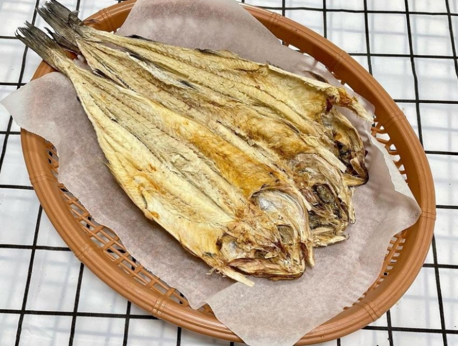 바다에서 채취를 한 명태를 바싹 말려서 만든 북어포를 바닥에 동그란 바구니에 휴지를 깔고 그 위에 3마리를 포개어 놓아두고 찍은 사진