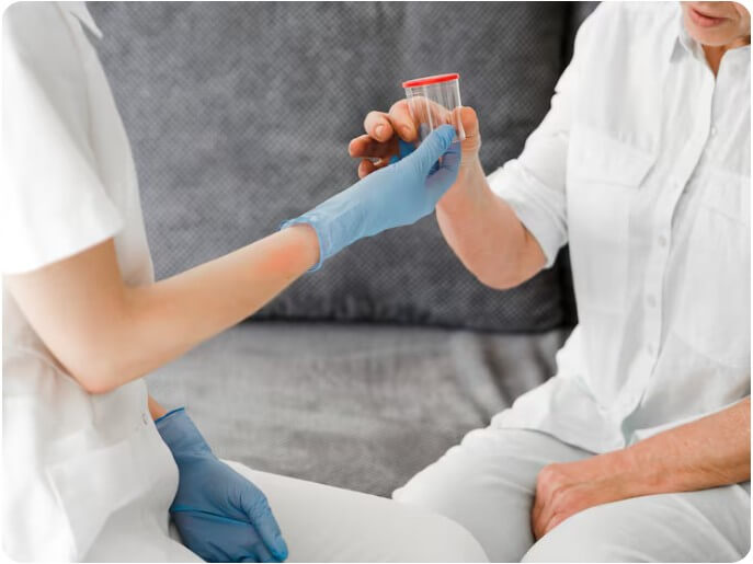 환자의 피를 채혈 후 피를 담아 놓은 통을 보고 있는 간호사