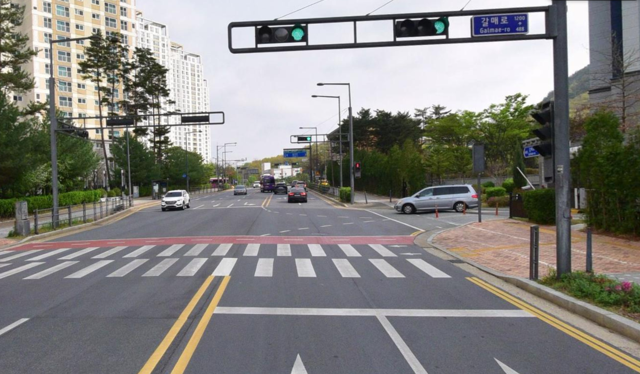 시내 도로 환경, 신호등과 횡단보도가 있는 교차로에서 차량들이 주행 중인 모습