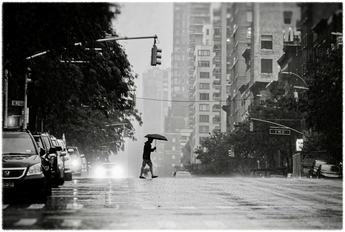 우산을-쓰고-도로를-건너가고-있는-남성