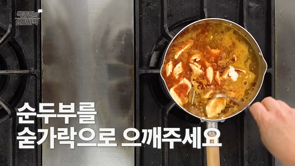순두부를 숟가락으로 으깨는 장면