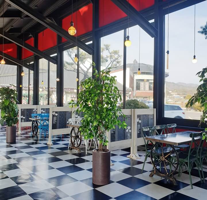 백운당제빵소의-오른쪽-자리의-테이블엔-바퀴가-달려있고-빈티지-느낌이-물씬-나고-통유리창으로-바깥-풍경이-보인다