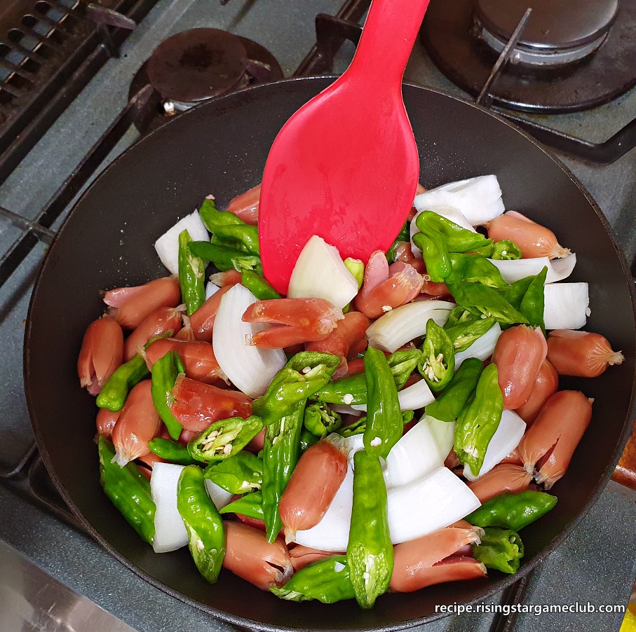 꽈리고추 소세지 볶음을 하기 위해 예열된 팬에 준비된 야채들을 넣은 사진