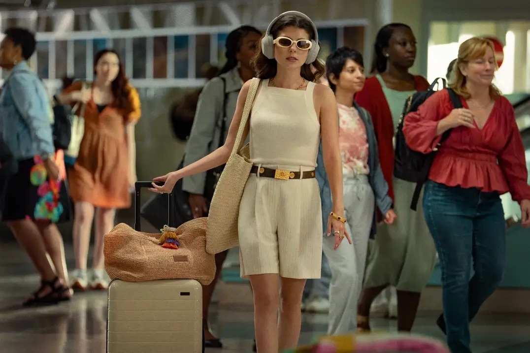 헤드폰과 선글라스를 낀 채 여행용 캐리어를 끌고 있는 파피