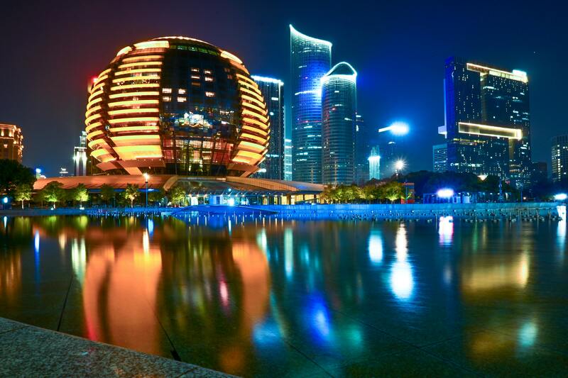 거대한 황금빛 구형 건물과 현대적인 고층빌딩이 어우러진 항저우의 도심 야경