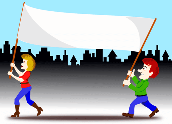 하얀 플랫카드를 들고있는 금발의 백인 여자와 붉은머리 백인 남자가 길을 걷고있다. 둘은 파란 청바지를 입었고 여자는 빨간 반팔티, 남자는 초록색 긴팔티를 입었다.