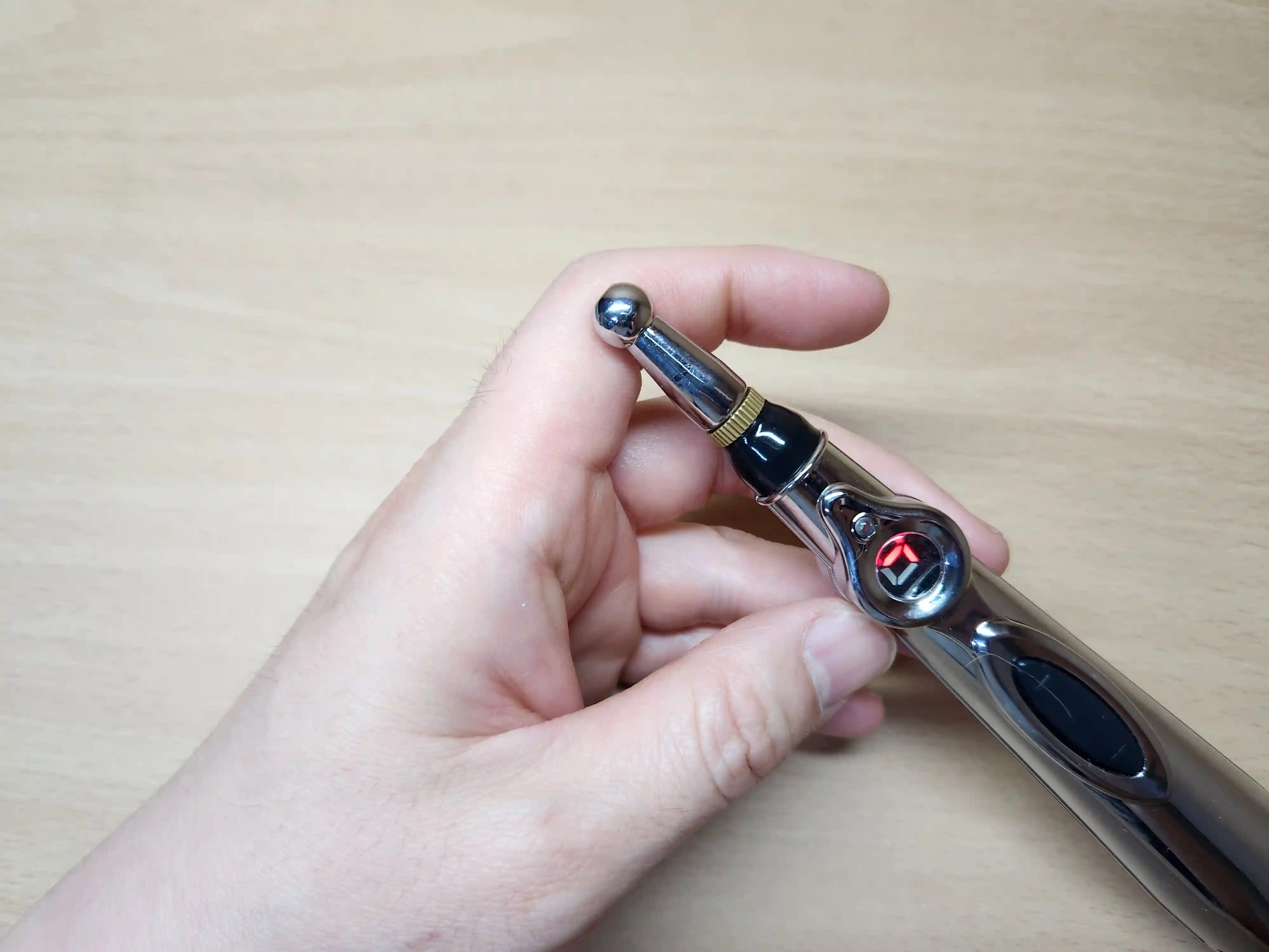 검지 관절에 EMS 마사지 펜으로 자극하는 이미지