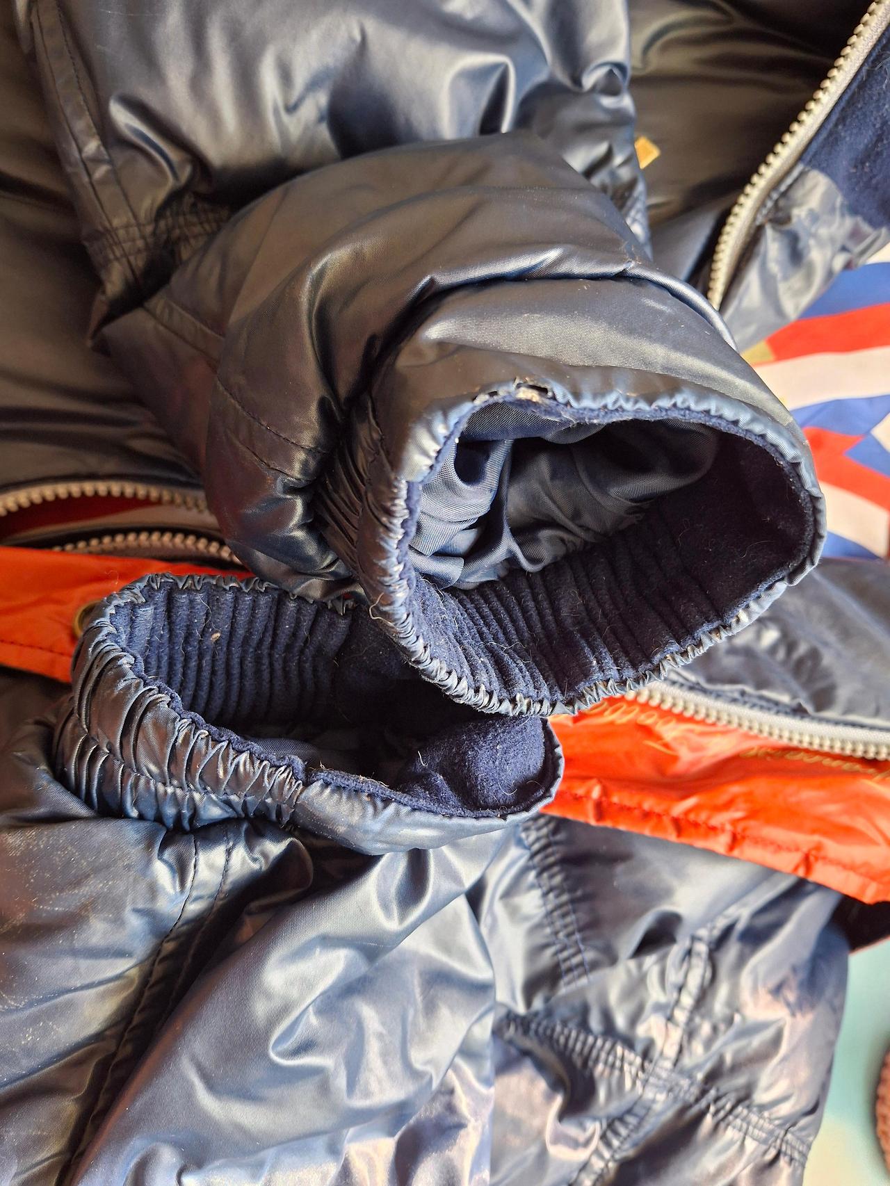 낡아서 실밥이 터져나온 패딩 소매 클로즈업 사진, 겨울옷 구매 시기를 고민하게 만듦.