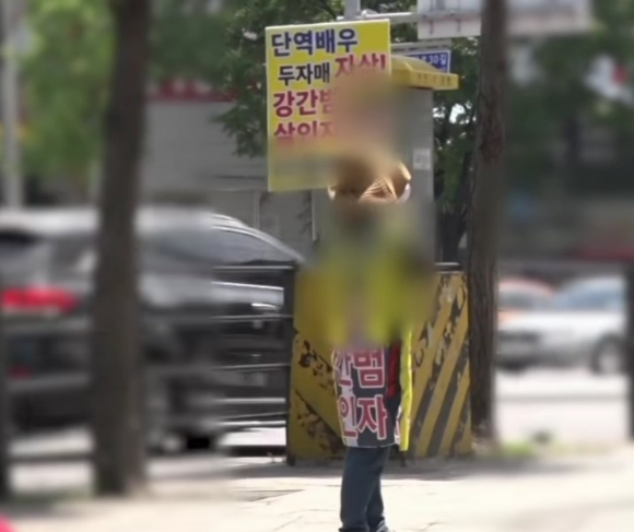 '단역배우 자매사건' 피해자의 어머니 장모씨가 가해자를 탄원하는 피켓을 들고 있다. [사진=KBS '제보자들' 캡쳐]