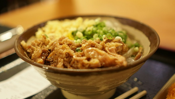 밥이 담긴 그릇 위에 냉동 삼겹살을 볶아서 올린 냉삼덮밥이다. 파를 송송 썰어서 장식했다