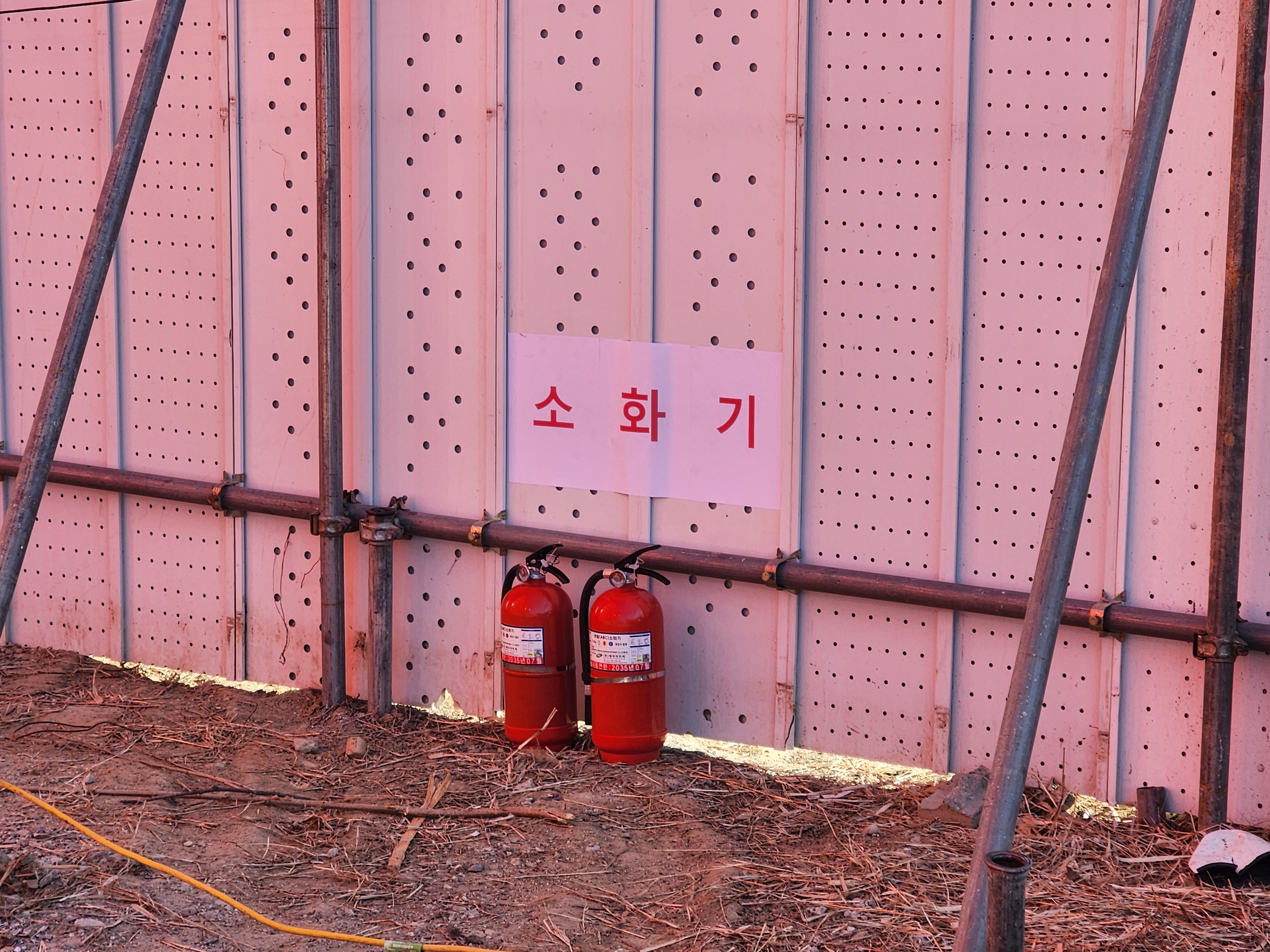 가설울타리 안쪽 소화기 표지 아래 비치한 소화기 두 대