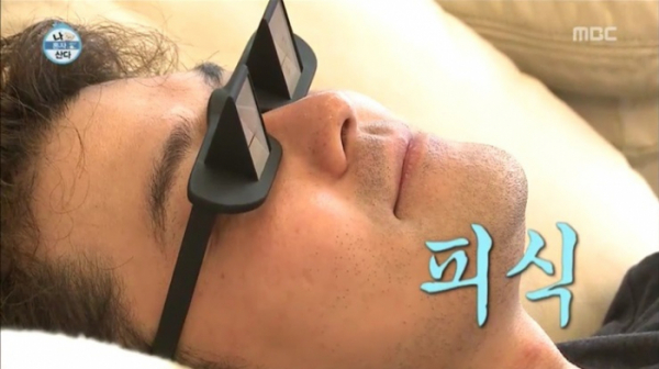 예능 프로그램에서 방송인이 누워서 TV 보는 안경을 착용하고 편안하게 누워 있는 모습