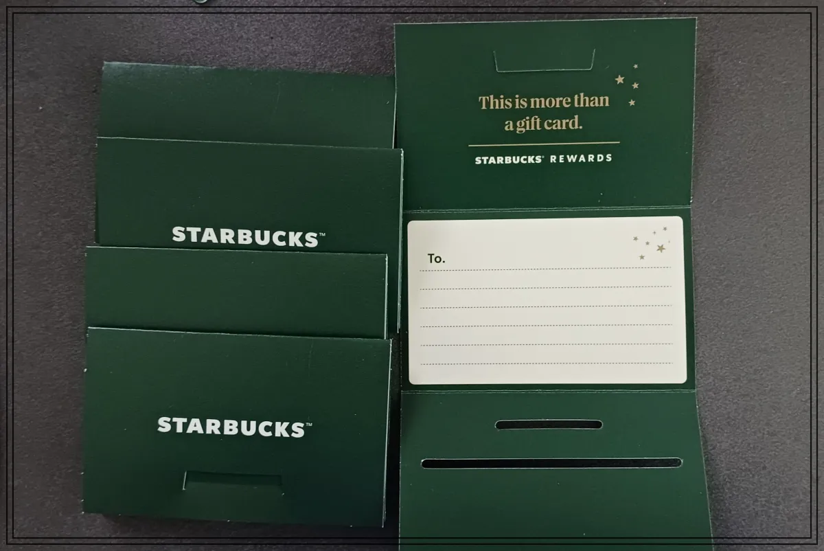 검은색-식탁위에-스타벅스-기프트카드-종이케이스-5개-4개는-모두-닫혀있고-1개는-안쪽모습을-볼-수-있게-펼쳐짐-케이스-안에-카드처럼-글을-쓸수-있음