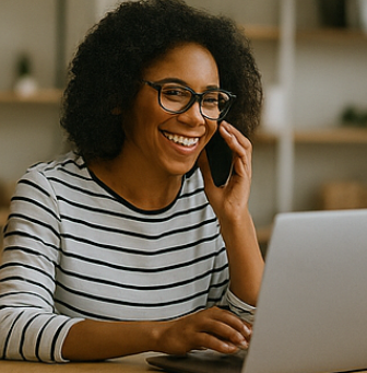 휴대전화로 통화하며 컴퓨터 작업을 하는 여성 사진