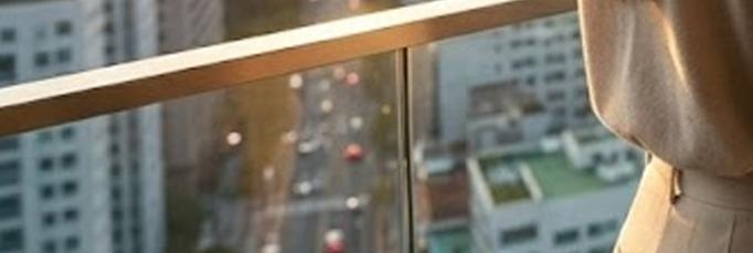 도시 경관이 내려다보이는 현대적인 사무실에서 한 여성이 태블릿을 통해 우상향하는 수익률 그래프를 확인하며 미소 짓고 있는 모습. 테이블 위에는 투자 성공을 상징하는 트로피들과 현금 뭉치&amp;#44; 그리고 부동산&middot;주식&middot;채권을 상징하는 상승 아이콘들이 배치되어 투자 전략의 성공과 경제적 자유를 시각적으로 표현한 이미지.