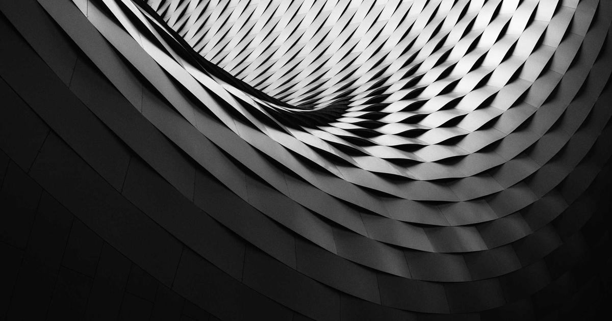 Happy young newlywed couple looking at laptop, planning their future home, with documents and a key on the table
