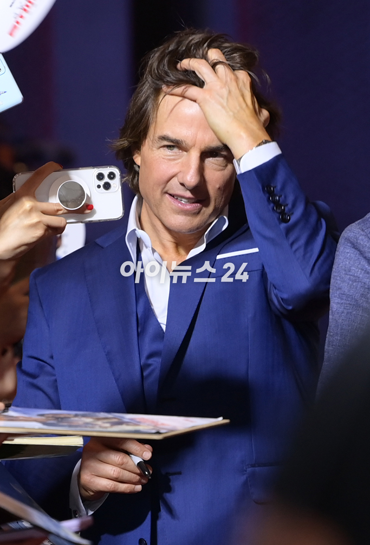 배우 톰 크루즈가 29일 오후 서울 송파구 롯데월드타워에서 진행된 영화 '미션 임파서블: 데드 레코닝 파트 원'(감독 크리스토퍼 맥쿼리) 내한 레드카펫 행사에 참석해 한 팬에게 자신의 얼굴이 새겨진 부채를 받고 기뻐하고 있다. [사진=정소희 기자]