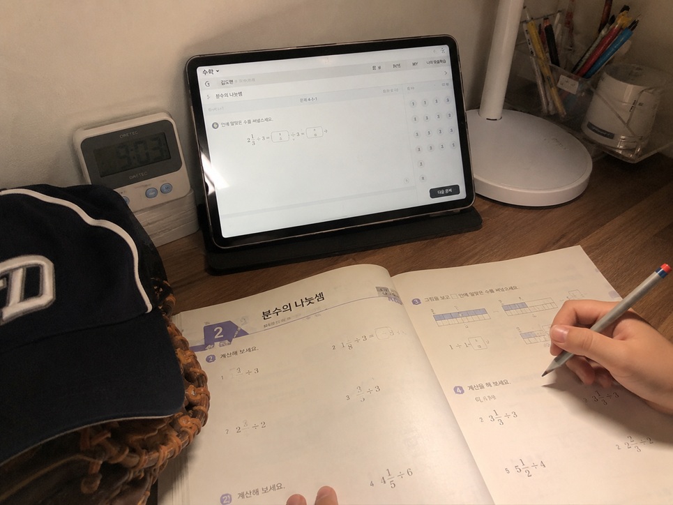야구 훈련 후 집에서 태블릿과 문제집으로 자습하는 초등학생의 공부 모습