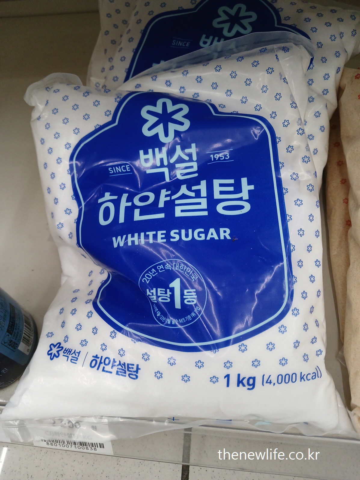 1kg bag of white sugar (백설 brand), labeled with 4,000 kcal – refined sugar product on shelf-백설 하얀설탕 1kg 제품 – 4,000kcal 표기가 있는 정제 백설탕 포장 이미지